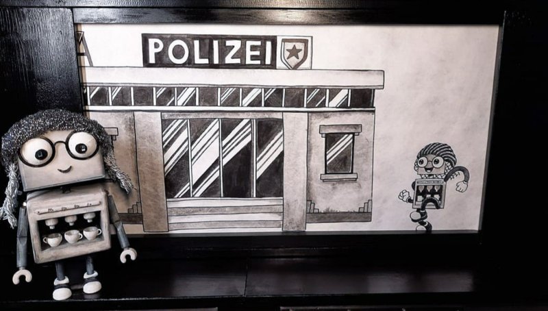A small robot with a coffee machine as its body is standing in front of a drawn police station.