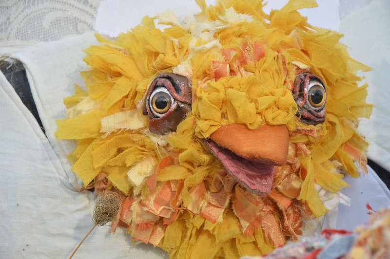 A bif chick puppet, made aut of hundres og yellow and orange pieces of fabric, cracks out of an egg shell.