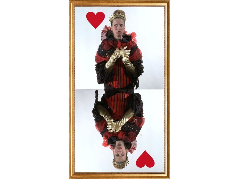 Eine Frau die als die Herzdame gekleidet ist, wird auf einer Spielkarte abgebildet.