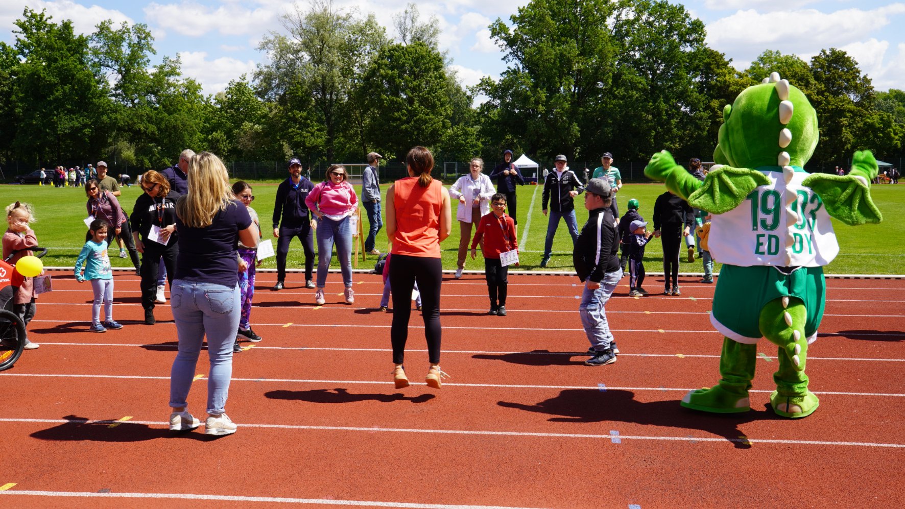 Hüpfende Teilnehmende und das Maskottchen Edy von der Spielvereinigung Greuther Fürth