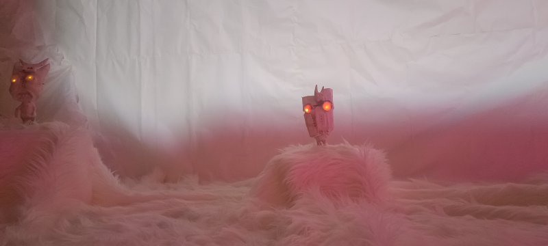 Zwei roboterartige Wesen mit leuchtenden Augen