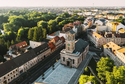 Luftaufnahme der Kirche Unsere Liebe Frau in Fürth mit umliegenden Gebäuden und viel Grün im Hintergrund