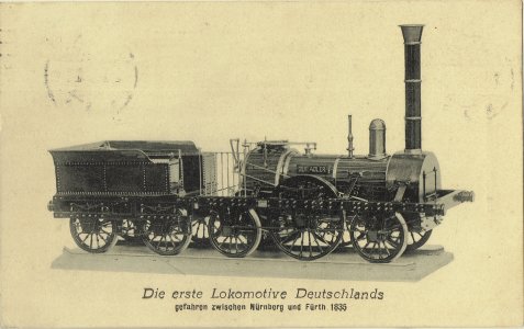 Schwarz-weiße Abbildung der ersten deutschen Lokomotive "Der Adler", seitliche Ansicht, darunter Text mit Baujahr 1835 und Einsatzort Nürnberg-Fürth.