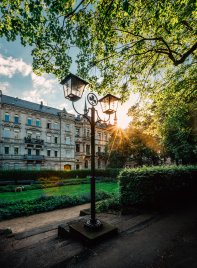 Historische Straßenlaterne mit Kleeblattsymbol, im Hintergrund die Luisenanlage und eine Häuserzeile der Hornschuchpromenade