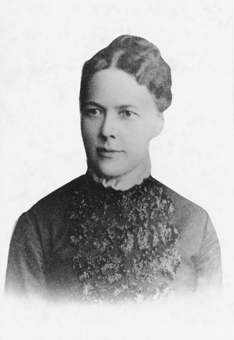 Schwarz-weiß-Porträt von Emilie Lehmus mit hochgestecktem Haar und einem Kleid mit floraler Spitze am Oberteil.