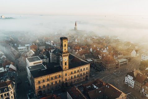 Luftaufnahme des Fürther Rathaus bei Nebel, im Hintergrund der Kirchturm von St. Michael, umgeben von Häusern und Straßen.