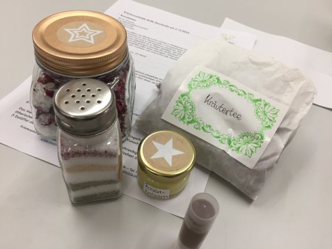 Mehrere Behälter mit Gewürzen und Kräuterteebeutel auf einem weißen Blatt Papier