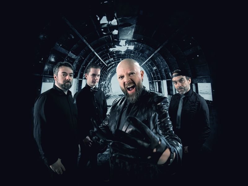 Vier Männer stehen vor einer schwarzen Wand.