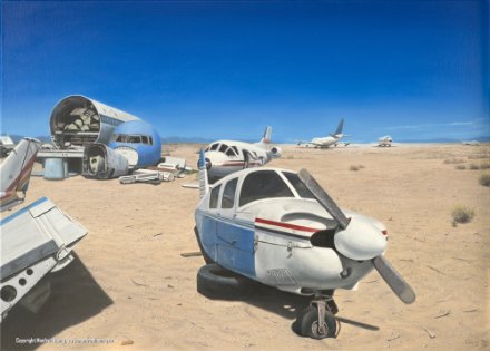 Verlassene Flugzeuge unterschiedlicher Größe stehen auf sandigem, trockenem Gelände unter blauem Himmel