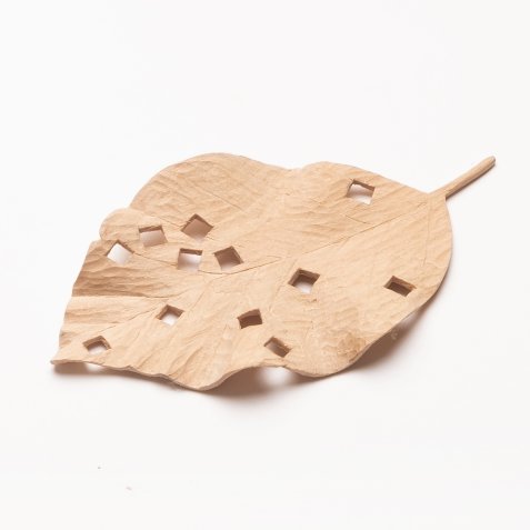 Geschnitztes Blatt aus Holz mit mehreren quadratischen Löchern