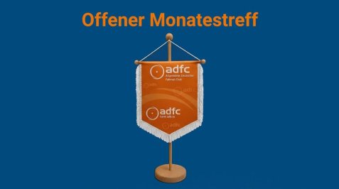 Ein orangefarbener Wimpel mit weißem Fransenrand auf einem Holzständer vor blauem Hintergrund mit dem Text 'Offener Monatstreff' in Orange darüber