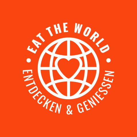 Weißes Logo mit stilisierter Weltkugel und Herz in der Mitte auf orangefarbenem Hintergrund mit dem Text 'EAT THE WORLD' oben und 'ENTDECKEN & GENIESSEN' unten