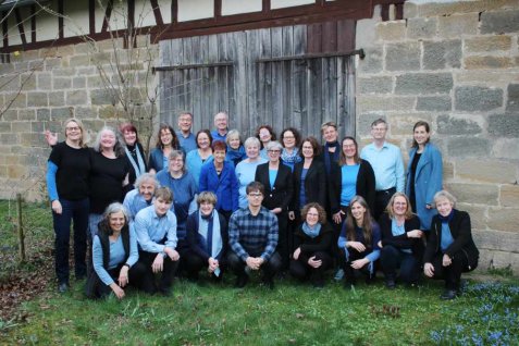 Gospelchor Blue Notes posiert vor einer alten Steinmauer mit Holztür auf einer Wiese