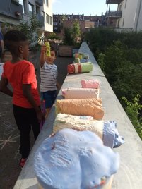 Zwei Kinder betrachten und zeigen selbstgemachte Straßenmalkreide.