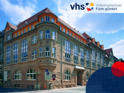 Historisches Sandsteingebäude der Volkshochschule Fürth mit markantem Erker und rot gedecktem Dach unter blauem Himmel.