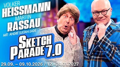 Volker Heißmann mit braunen Haaren und blauem Pullover macht eine überraschte Mimik vor blau-lila Hintergrund mit Text zur Veranstaltung.