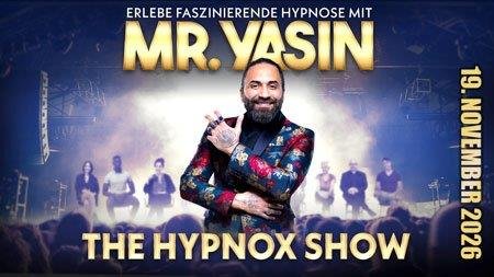 Mann mit Bart und buntem Sakko vor unscharfem Publikum und Text 'ERLEBE FASZINIERENDE HYPNOSE MIT MR. YASIN DIE HYPNOX SHOW 19. NOVEMBER 2026'