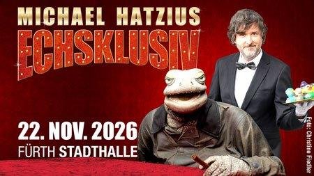 Werbeplakat mit der Aufschrift 'MICHAEL HATZIUS ECHSKLUSIV 22. NOV. 2026 FÜRTH STADTHALLE' und einer Echse mit rotem Anzug und Krawatte