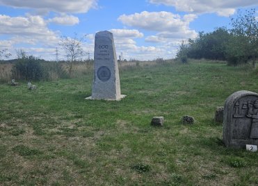 Ein Gedenkstein mit der Inschrift „600 Jahre Siebigerode“ steht auf einer Wiese, im Vordergrund ist eine weitere steinerne Gedenktafel zu sehen.